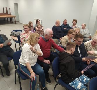 Seniorzy siedzący na krzesłach