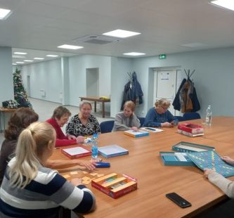 Seniorzy podczas gry przy wspólnym stole