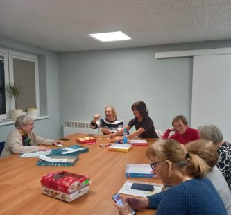 Seniorzy podczas gry przy wspólnym stole 
