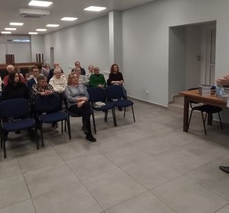 Seniorzy siedzący na krzesłach