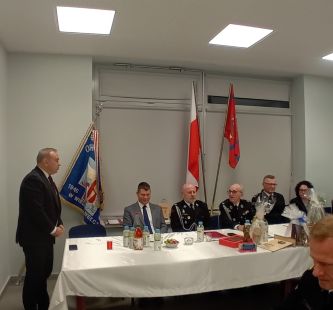 Na zdjęciu Wójt Gminy Grudziądz zabiera głos podczas zebrania, w tle druhny i druhowie oraz zaproszeni goście