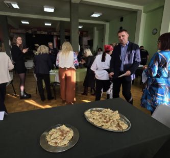 na pierwszym planie widać potrawy, w tle zgromadzeni goście